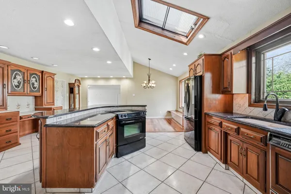 a kitchen with stainless steel appliances granite countertop a stove a sink dishwasher and a refrigerator