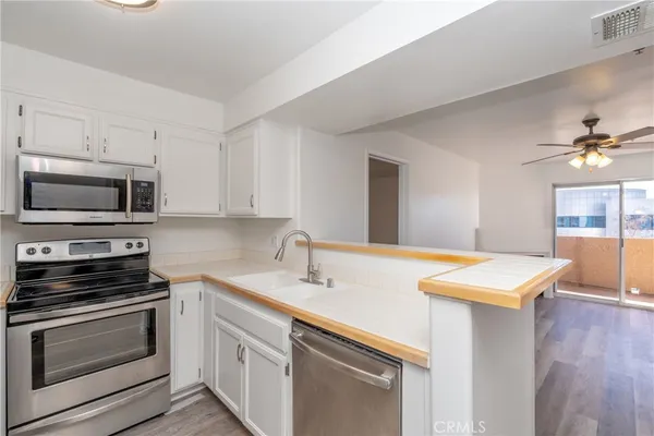a kitchen with stainless steel appliances a stove microwave and sink