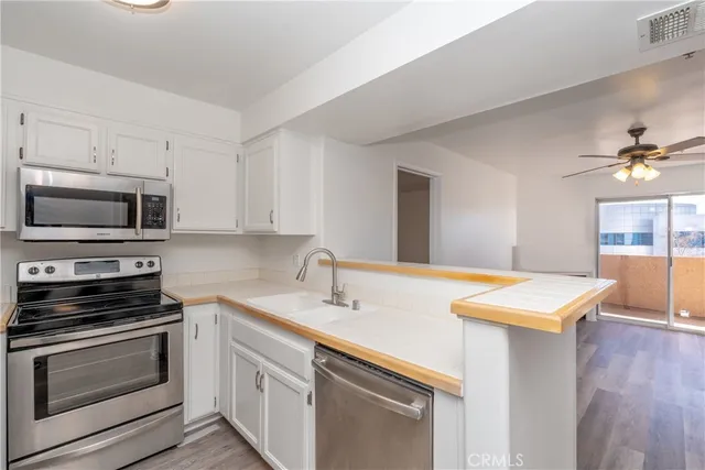 a kitchen with stainless steel appliances a stove microwave and sink