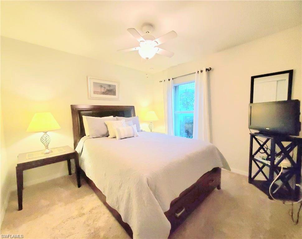 8657 Querce Court Naples, FL 34114 - Photo 13 of 44 a bedroom with a bed and a chandelier