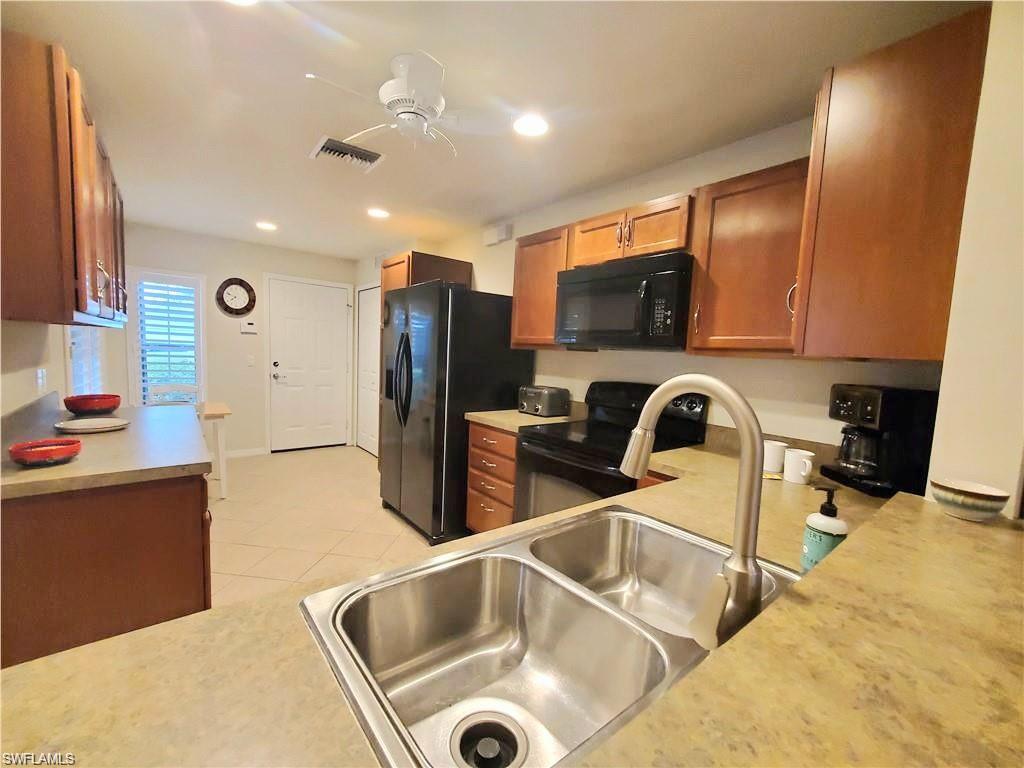 8657 Querce Court Naples, FL 34114 - Photo 24 of 44 a kitchen with stainless steel appliances granite countertop a sink a stove and a refrigerator