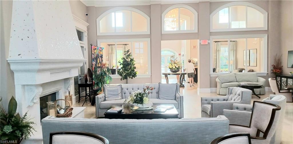 8657 Querce Court Naples, FL 34114 - Photo 42 of 44 a living room with furniture fireplace and large windows