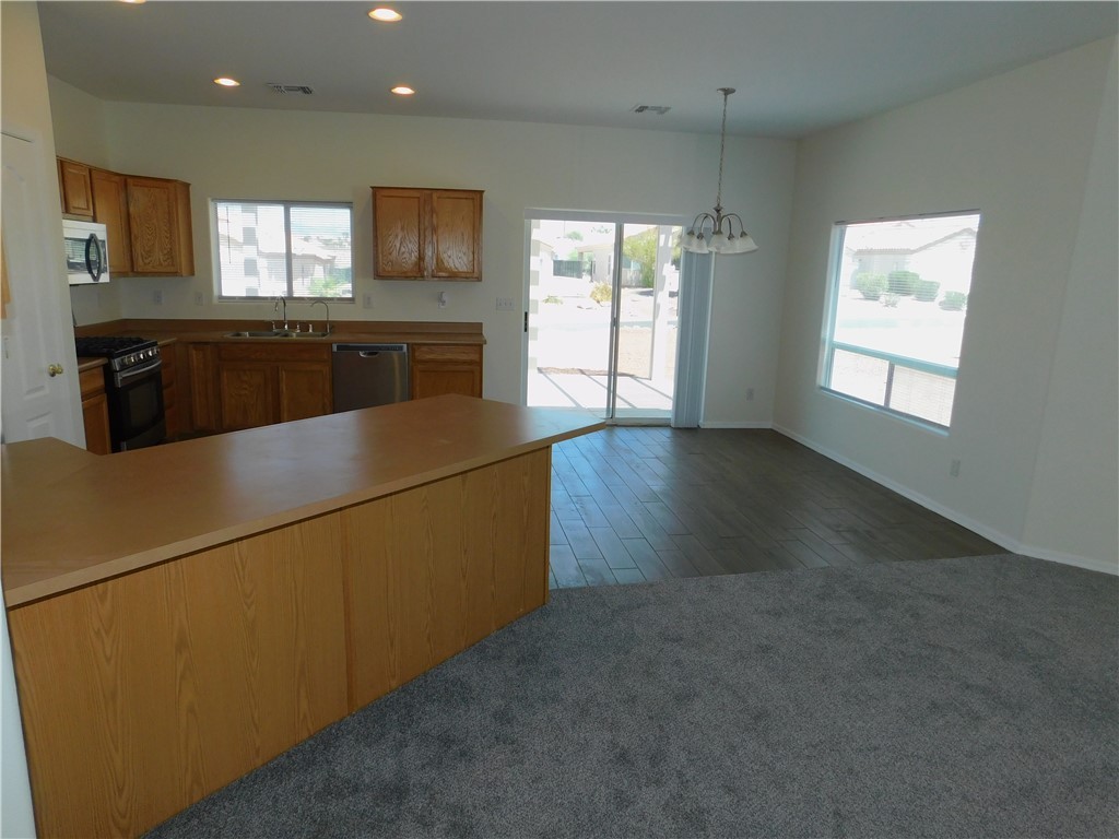 2449 Wilder Road Bullhead City, AZ 86442 - Photo 22 of 45 a kitchen with kitchen island a sink wooden floor and a refrigerator