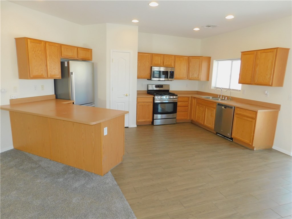 2449 Wilder Road Bullhead City, AZ 86442 - Photo 23 of 45 a large kitchen with stainless steel appliances a sink a stove a refrigerator a washer and dryer
