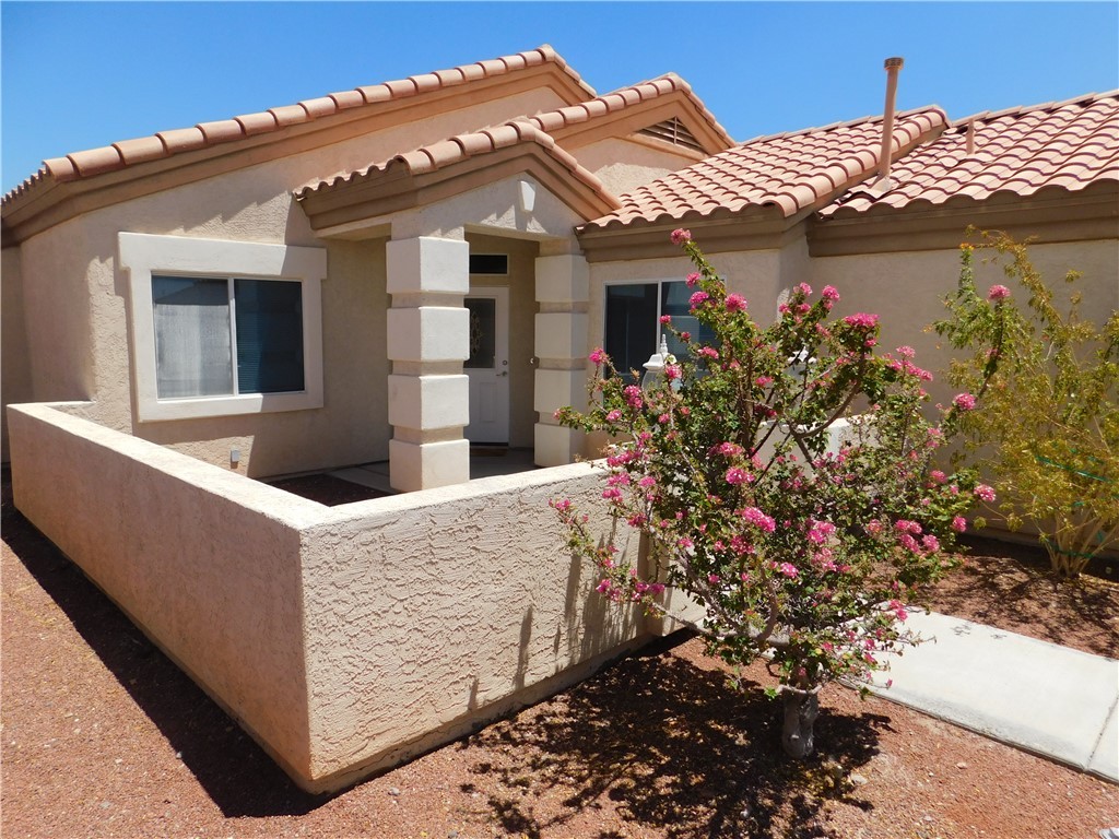 2449 Wilder Road Bullhead City, AZ 86442 - Photo 6 of 45 a view of a white house with a flower garden in front of it