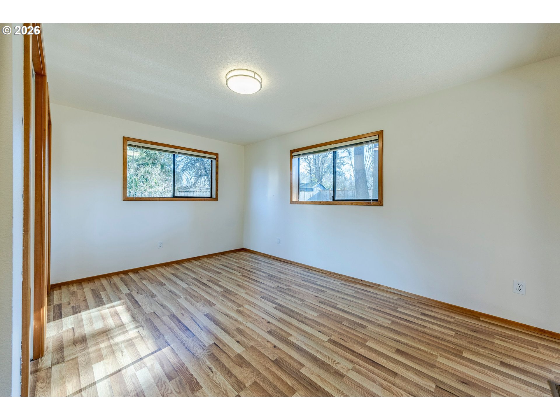 3248 West 15th Avenue Eugene, OR 97402 - Photo 21 of 33 a view of an empty room with wooden floor and a window
