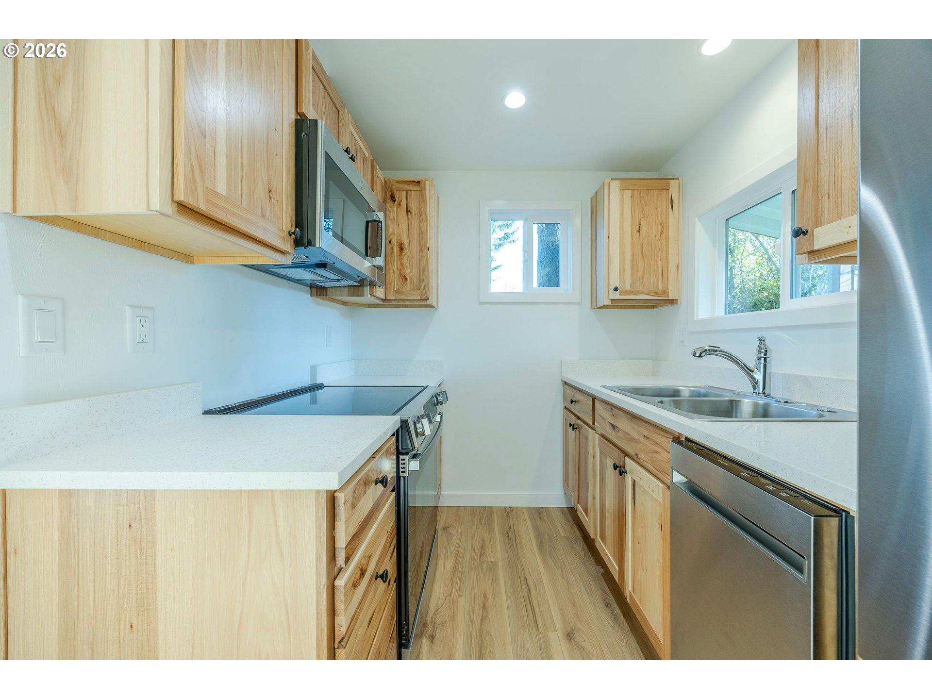 3248 West 15th Avenue Eugene, OR 97402 - Photo 25 of 33 a kitchen with a sink a stove cabinets and a wooden floor