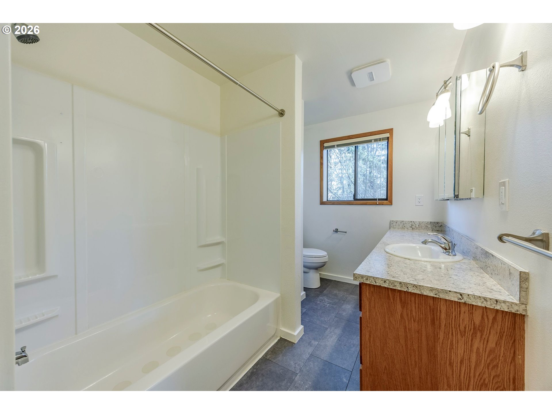 3248 West 15th Avenue Eugene, OR 97402 - Photo 27 of 33 a bathroom with a granite countertop sink a toilet and bathtub