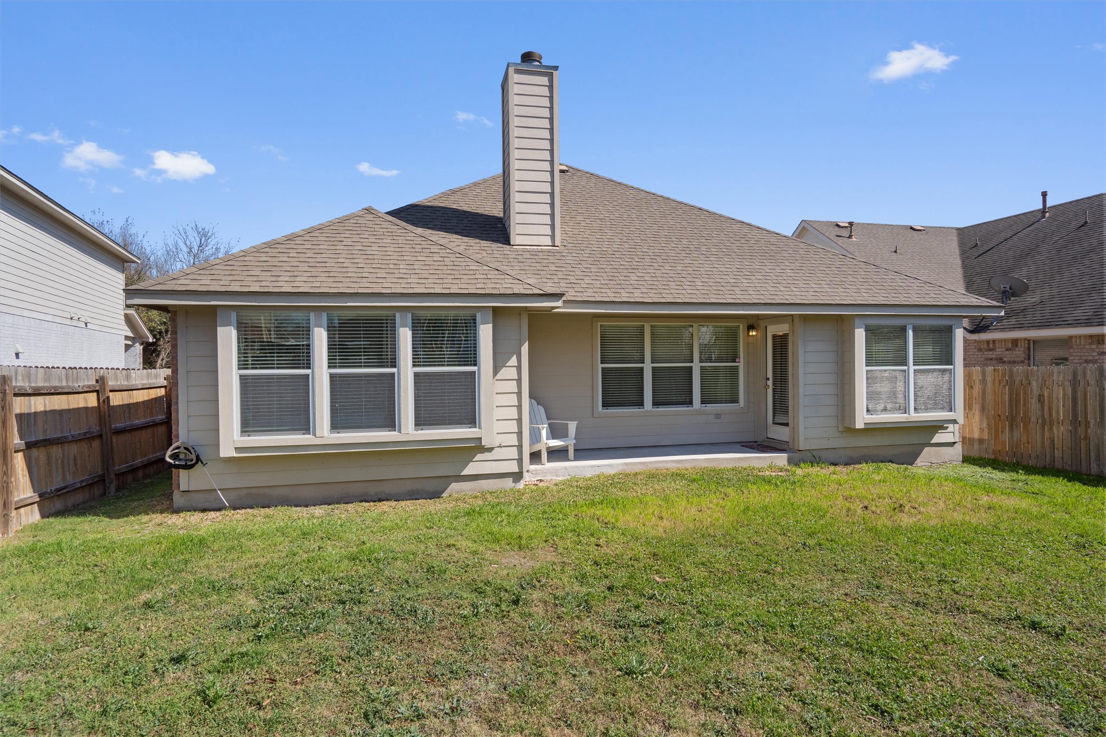 2801 Kickapoo Cavern Drive Pflugerville, TX 78660 - Photo 31 of 38 Rear view of house featuring a fenced backyard, a patio, a shingled roof, and a chimney