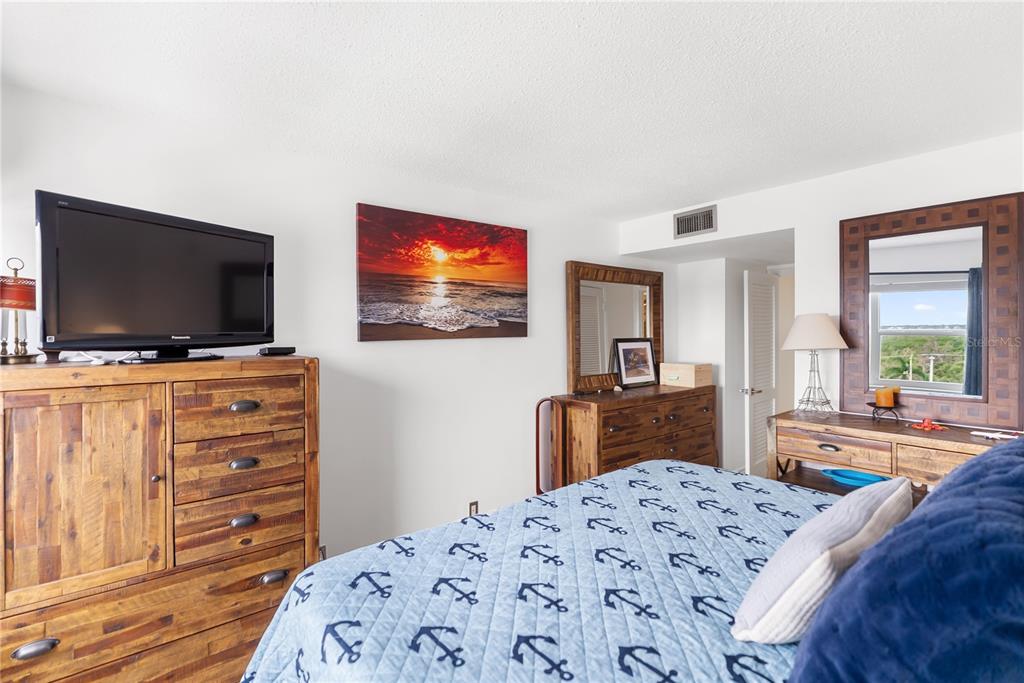 1750 Benjamin Franklin Drive, Unit 6G Sarasota, FL 34236 - Photo 17 of 82 a bedroom with a bed and a flat screen tv in it