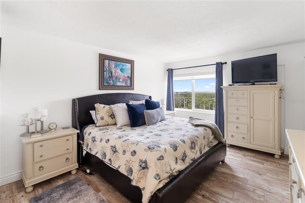 1750 Benjamin Franklin Drive, Unit 6G Sarasota, FL 34236 - Photo 25 of 82 a bedroom with a bed and a flat screen tv