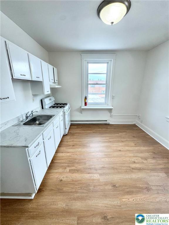 819 East 5th Street, Unit 2 Bethlehem, PA 18015 - Photo 3 of 19 a kitchen with granite countertop a stove a sink and white cabinets with wooden floor