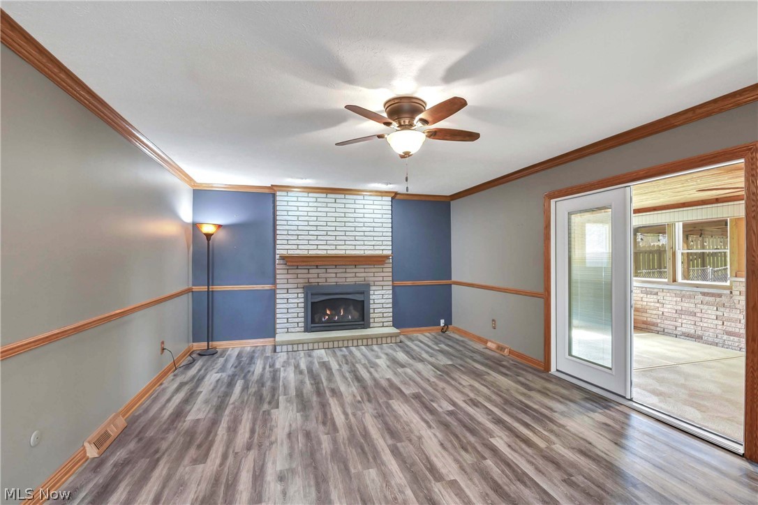 7350 Ames Road Parma, OH 44130 - Photo 13 of 50 Family room view of blue accent wall, fireplace with brick surround, would mantel and black gas insert