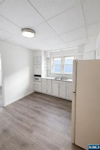 a view of a kitchen with a sink and a refrigerator