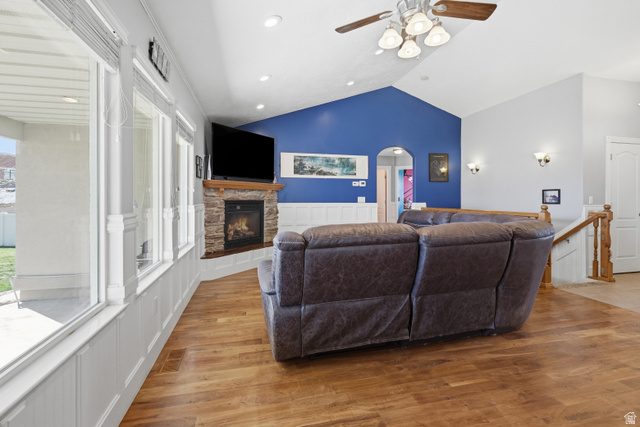 860 West 2980th Street South Logan, UT 84321 - Photo 5 of 38 Vaulted ceiling living area featuring wood-finish flooring, a stone-surround fireplace with a wood mantle, and a wall of windows above wainscoting