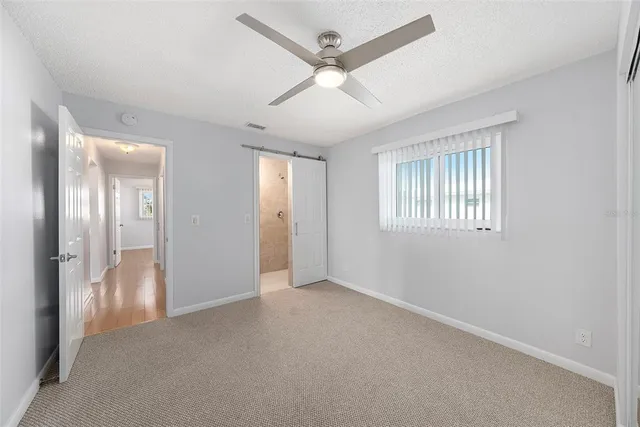 an empty room with fan and windows