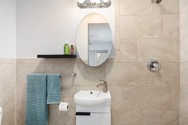 a bathroom with a sink toilet and mirror