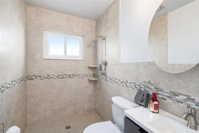 a bathroom with a sink mirror toilet and shower