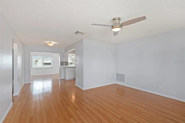 a view of empty room with wooden floor and window