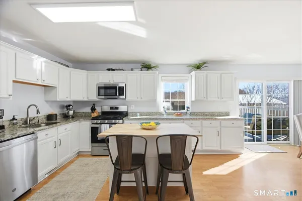 a kitchen with a sink a stove a refrigerator a center island and cabinets