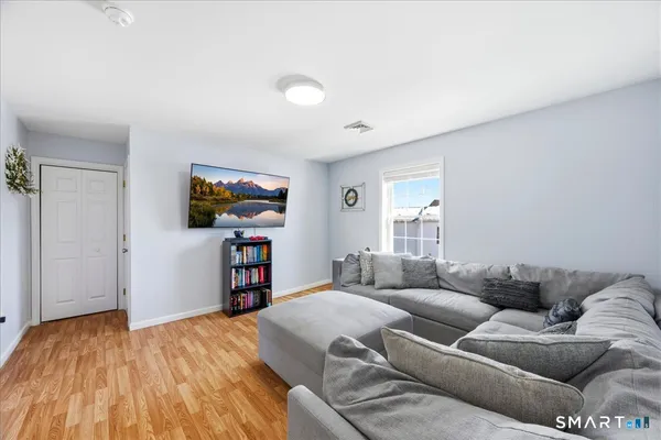 a living room with a bed and a flat screen tv