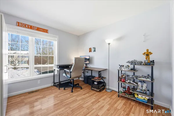 a view of a workspace with furniture and a window
