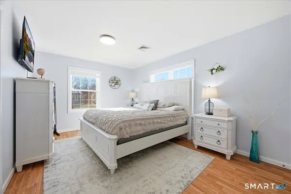 a spacious bedroom with a bed and a flat screen tv