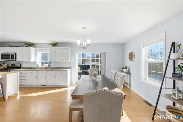 a large kitchen with granite countertop a large counter top appliances and cabinets
