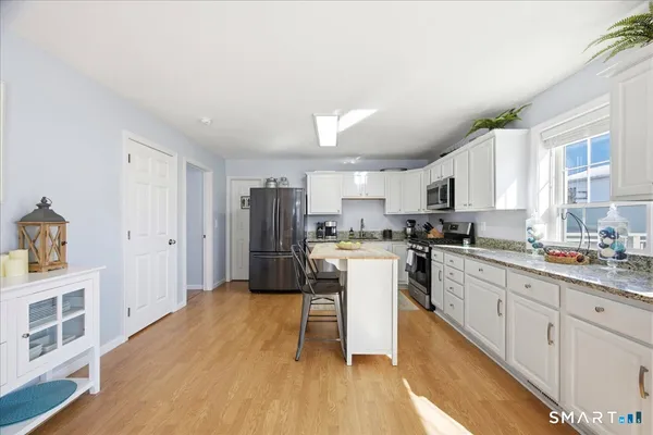 a kitchen with white cabinets and stainless steel appliances
