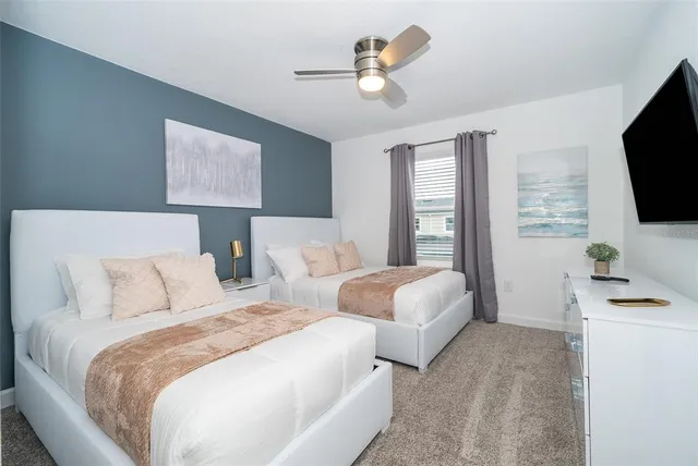 a bedroom with two separate beds and a flat screen tv