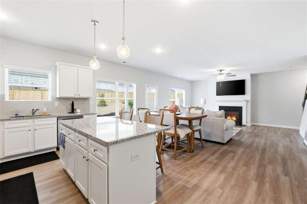 11817 Rizvan Place Covington, GA 30014 - Photo 13 of 40 a kitchen with sink stove microwave and wooden floor
