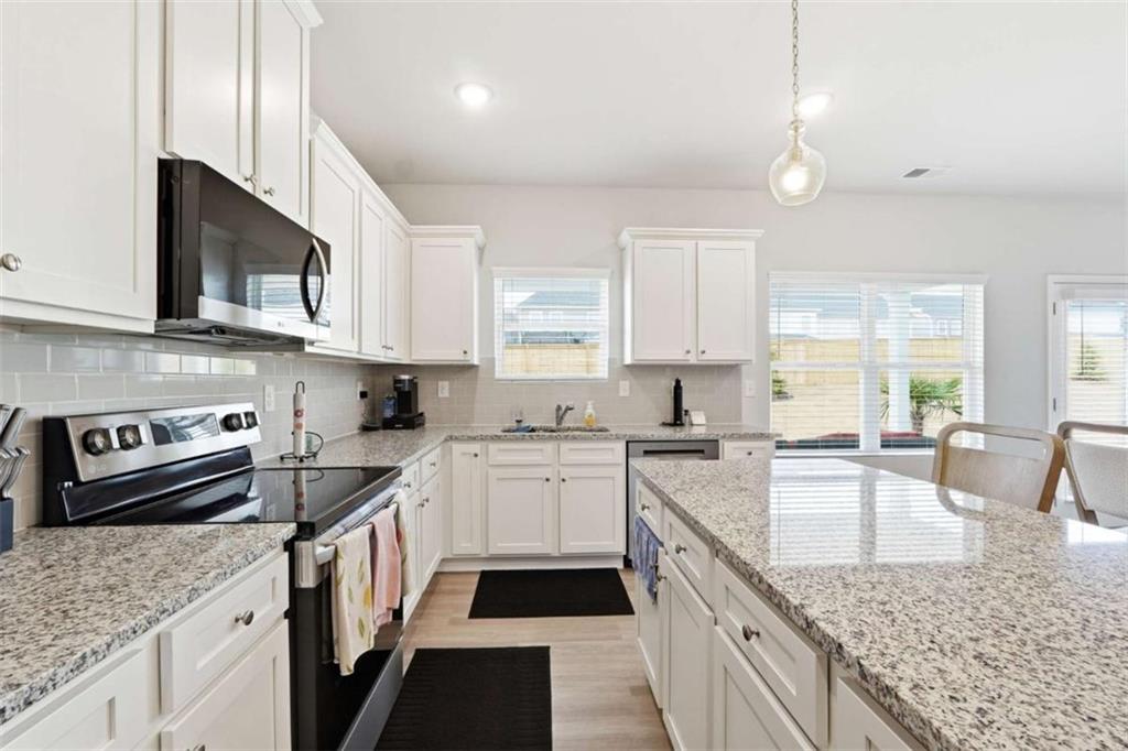 11817 Rizvan Place Covington, GA 30014 - Photo 14 of 40 a kitchen with stainless steel appliances granite countertop a sink stove and cabinets