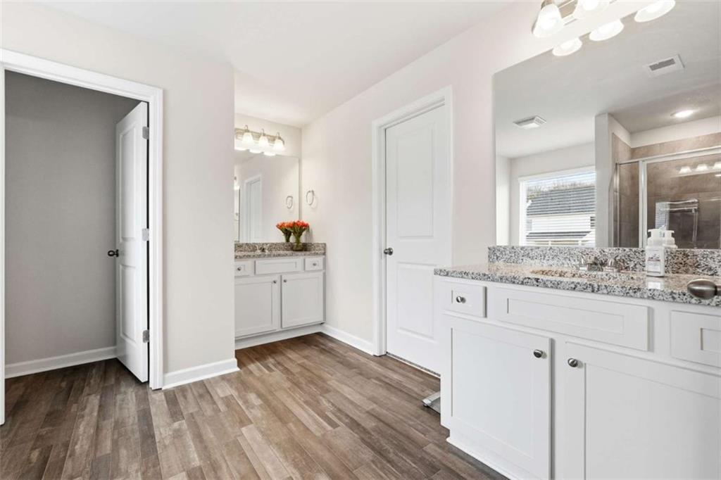 11817 Rizvan Place Covington, GA 30014 - Photo 22 of 40 a bathroom with a sink a mirror and a bathtub