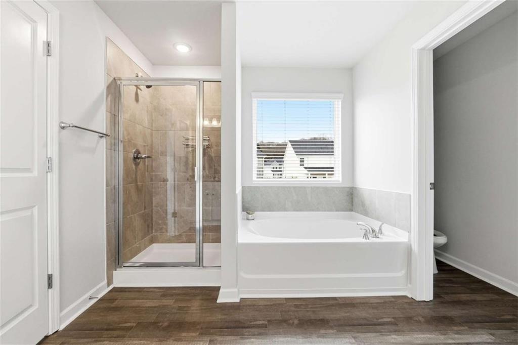 11817 Rizvan Place Covington, GA 30014 - Photo 23 of 40 a bathroom with a bathtub and a shower