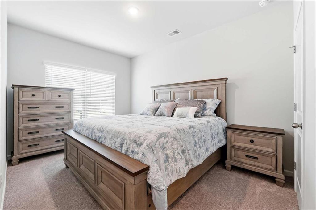 11817 Rizvan Place Covington, GA 30014 - Photo 25 of 40 a spacious bedroom with a bed and a window