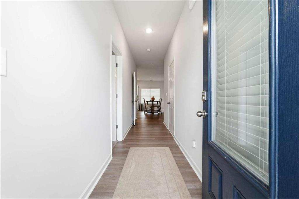 11817 Rizvan Place Covington, GA 30014 - Photo 3 of 40 a view of a hallway with wooden floor and a bathroom