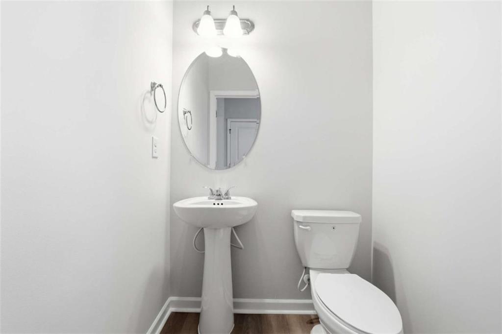 11817 Rizvan Place Covington, GA 30014 - Photo 36 of 40 a bathroom with a toilet sink and mirror