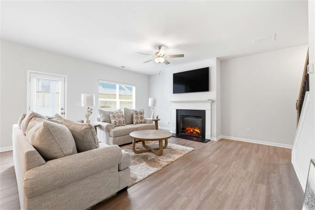 11817 Rizvan Place Covington, GA 30014 - Photo 6 of 40 a living room with furniture a flat screen tv and a fireplace