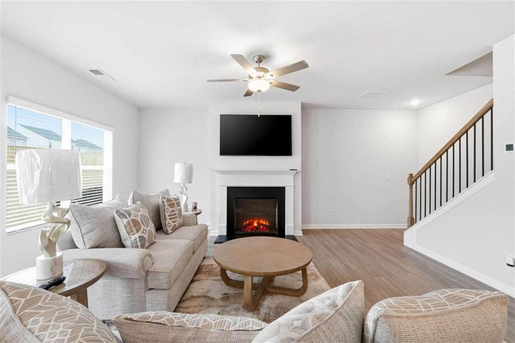 11817 Rizvan Place Covington, GA 30014 - Photo 8 of 40 a living room with furniture a fireplace and a flat screen tv
