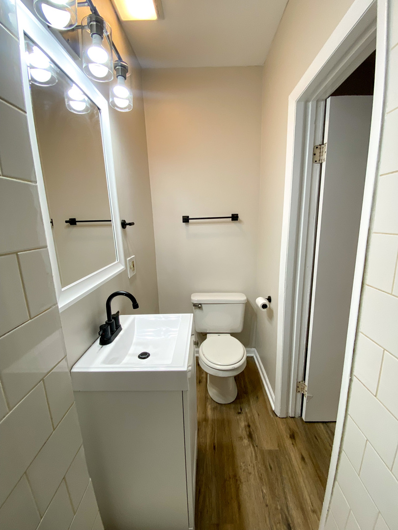 8933 South Halsted Street Chicago, IL 60620 - Photo 3 of 10 a bathroom with a sink a toilet and a mirror