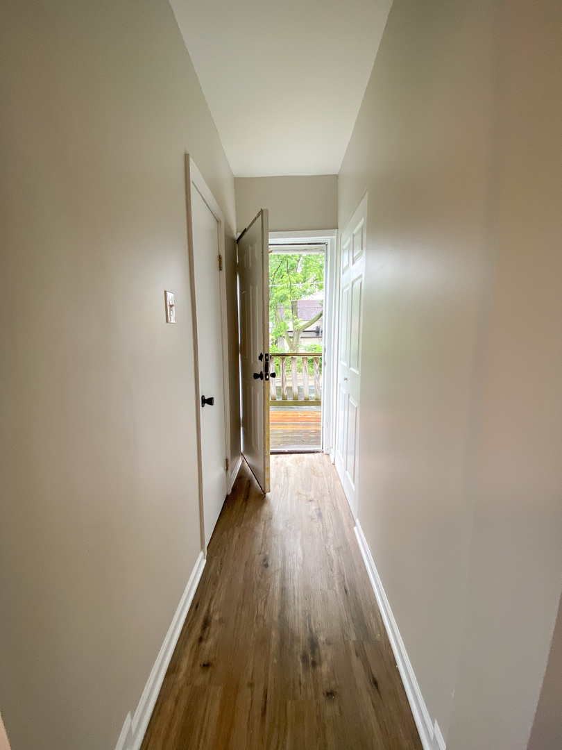 8933 South Halsted Street Chicago, IL 60620 - Photo 4 of 10 a view of a hallway with wooden floor and a window