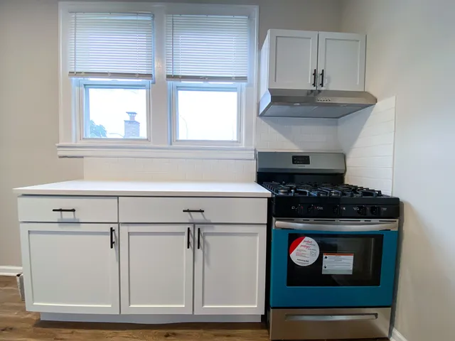 a stove top oven sitting inside of a kitchen