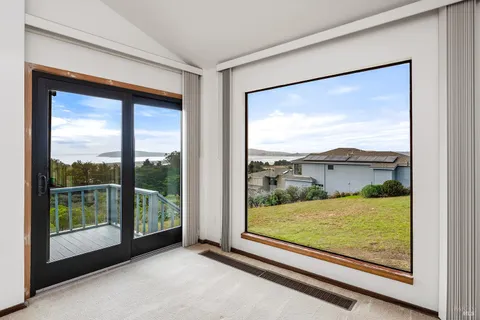 a view of a room with a large window and front door