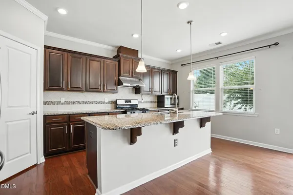 a kitchen with stainless steel appliances granite countertop a sink a stove and a refrigerator