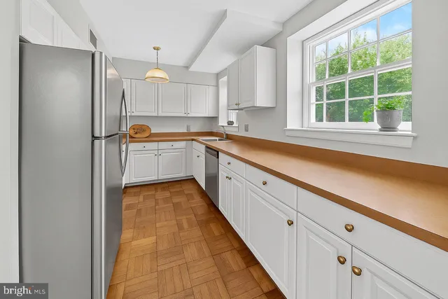 a large white kitchen with a sink and window