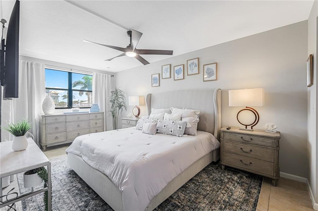 807 River Point Drive, Unit 102D Naples, FL 34102 - Photo 13 of 32 a bedroom with a bed and wooden floor
