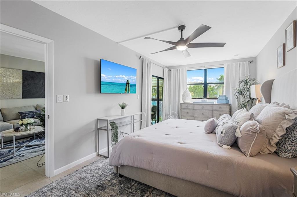 807 River Point Drive, Unit 102D Naples, FL 34102 - Photo 14 of 32 a bedroom with a bed and a chandelier
