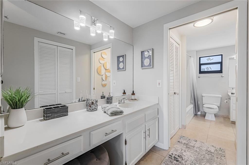 807 River Point Drive, Unit 102D Naples, FL 34102 - Photo 15 of 32 a bathroom with a sink a toilet and a large mirror
