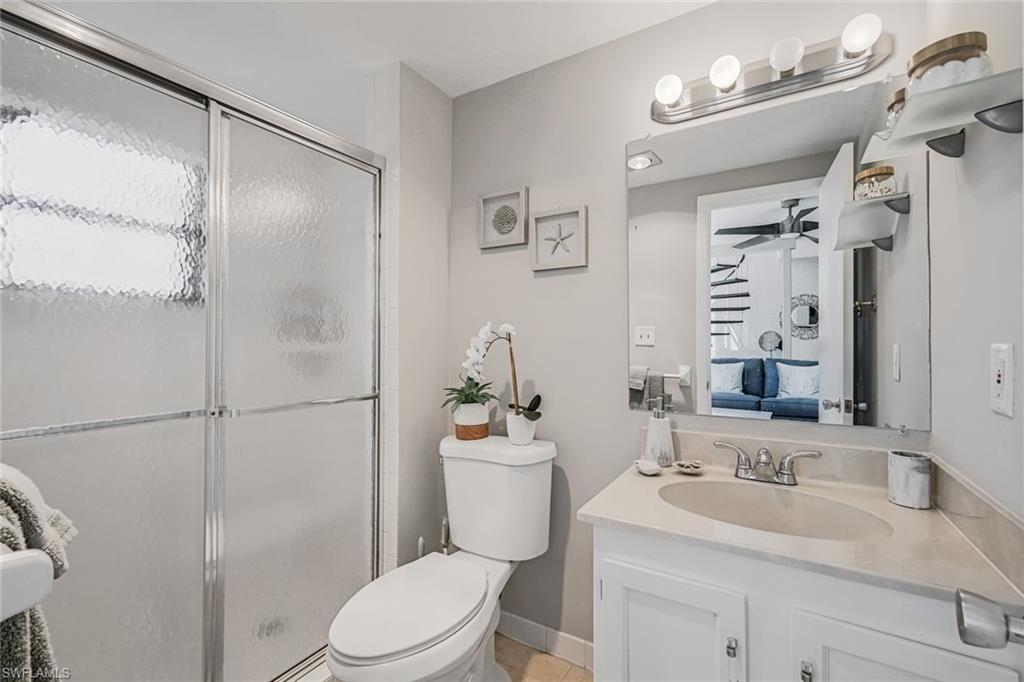 807 River Point Drive, Unit 102D Naples, FL 34102 - Photo 20 of 32 a bathroom with a sink a toilet a mirror and shower