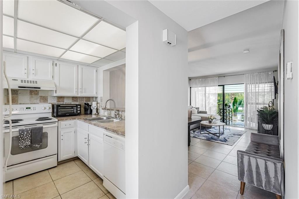 807 River Point Drive, Unit 102D Naples, FL 34102 - Photo 6 of 32 a kitchen with stainless steel appliances granite countertop a stove a sink and a refrigerator
